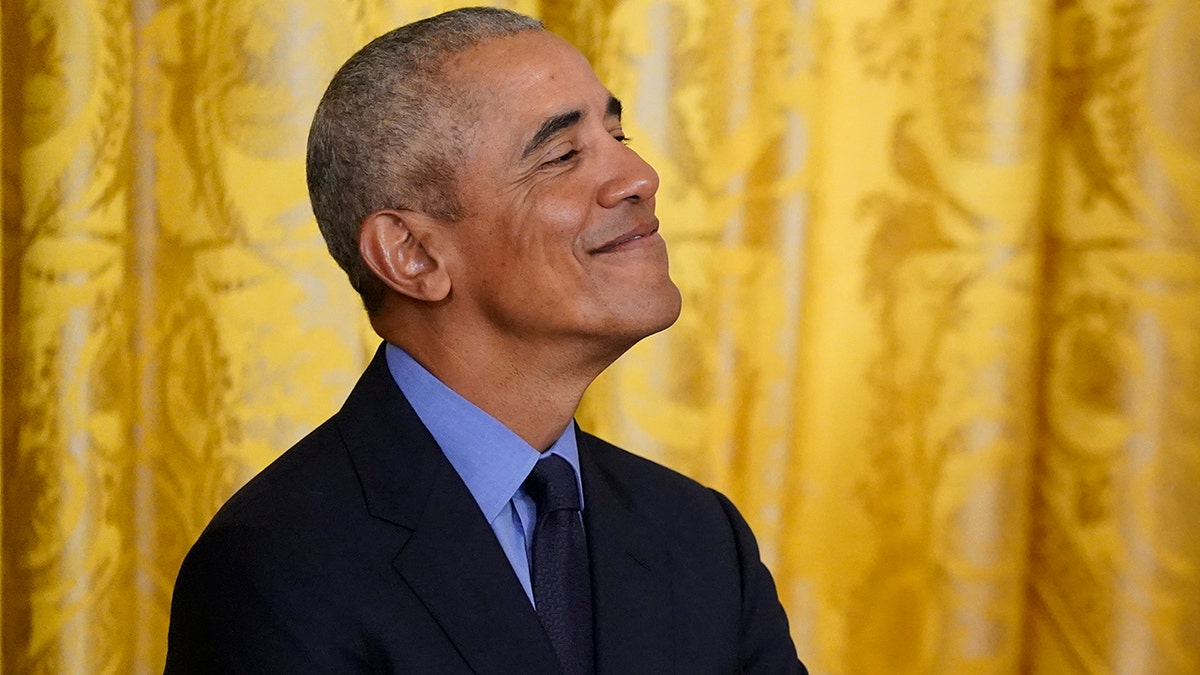 Former President Barack Obama looks on as President Biden speaks duding an event about the Affordable Care Act, in the East Room of the White House in Washington, Tuesday, April 5, 2022. (AP Photo/Carolyn Kaster)