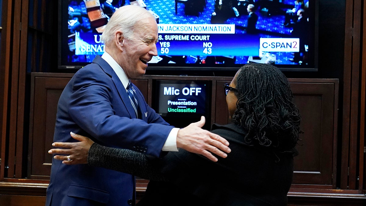President Biden goes to hug Supreme Court nominee Judge Ketanji Brown Jackson as they watch the Senate vote on her confirmation from the Roosevelt Room of the White House in Washington, Thursday, April 7, 2022. (AP Photo/Susan Walsh)
