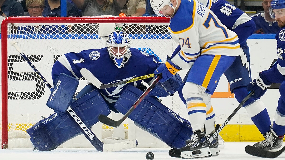 Tampa Bay Lightning goaltender Brian Elliott (1) keeps an eye on the puck as Buffalo Sabres center Rasmus Asplund (74) and Lightning center Steven Stamkos (91) battle for control during the second period of an NHL hockey game Sunday, April 10, 2022, in Tampa, Fla. 