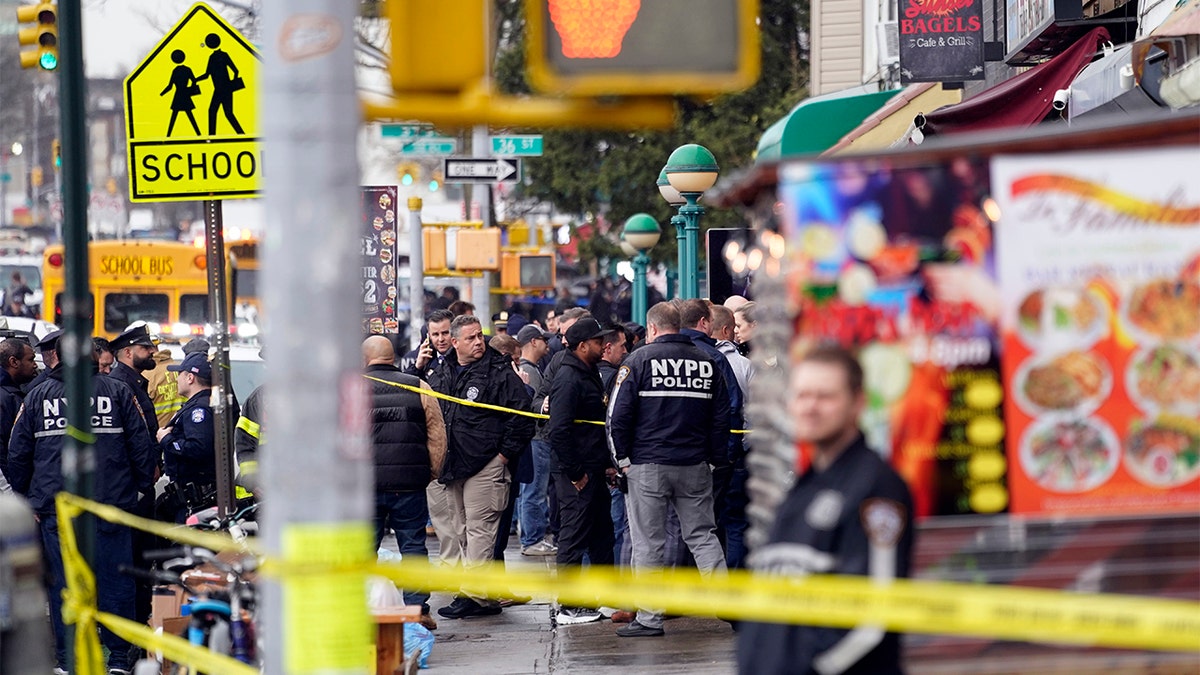 New York City Police Department personnel gather at the entrance to a subway stop in the Brooklyn borough of New York, Tuesday, April 12, 2022. (AP Photo/John Minchillo)