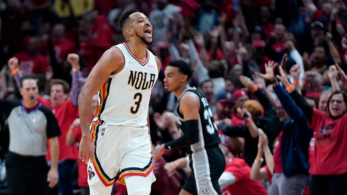 New Orleans Pelicans guard CJ McCollum (3) reacts with the crowd after scoring a 3-point basket in the first half of an NBA play-in basketball game against the San Antonio Spurs in New Orleans, Wednesday, April 13, 2022. 