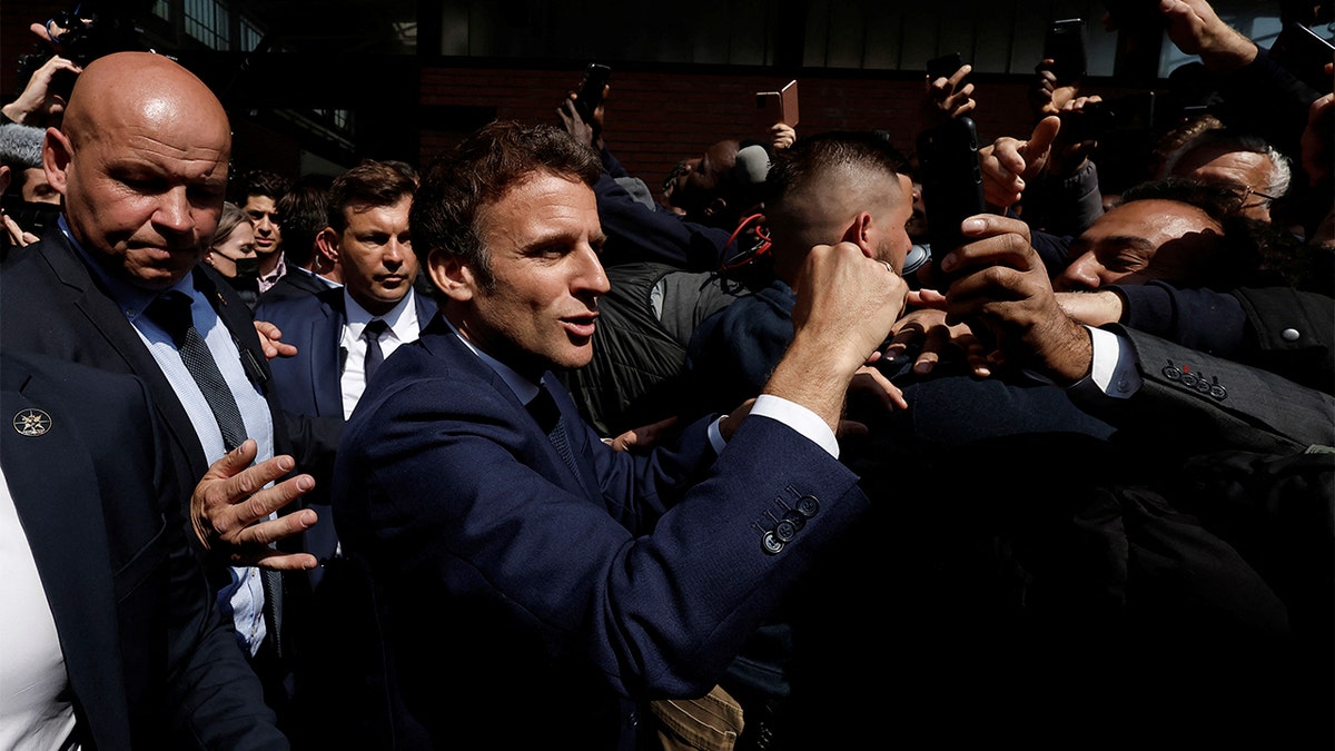 Newly re-elected French President Emmanuel Macron meets residents at the Saint-Christophe market square in Cergy, a Paris suburb, Wednesday, April 27, 2022. (Benoit Tessier, Pool via AP)