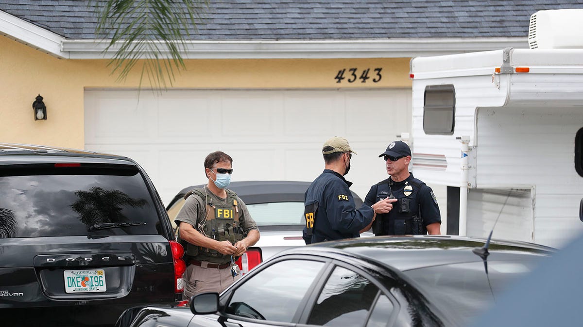 FBI agents talks with a North Port officer while they collect evidence from the home of Brian Laundrie on Sept. 20, 2021 in North Port, Florida. 