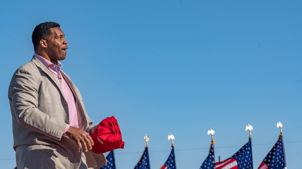 Former Heisman Trophy winner and candidate for US Senate Herschel Walker (R-GA) throws hats to supporters of former U.S. President Donald Trump during a rally at the Banks County Dragway on March 26, 2022 in Commerce, Georgia.