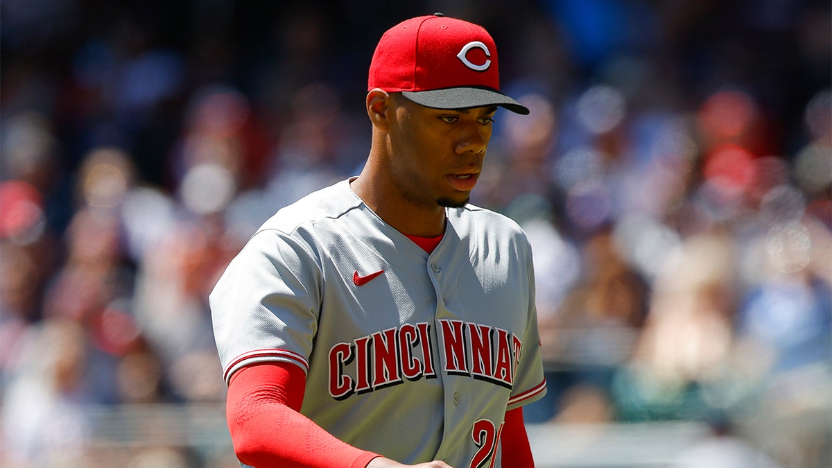 Hunter Greene #21 of the Cincinnati Reds returns to the dugout in the first inning of his MLB debut against the Atlanta Braves at Truist Park on April 10, 2022 in Atlanta, Georgia.