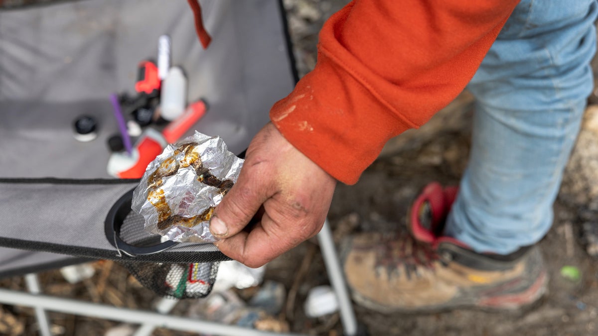 A homeless man holding a piece of aluminum foil used to smoke fentanyl in Seattle