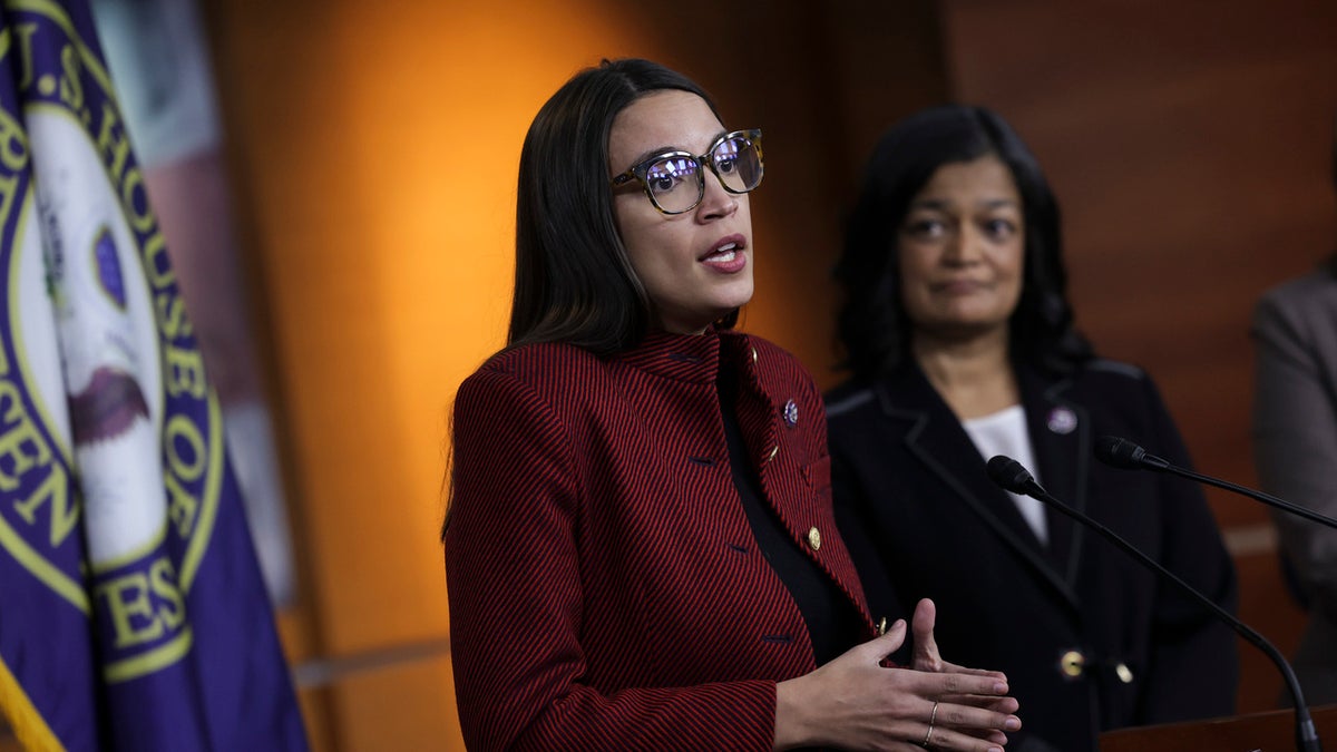 Alexandria Ocasio-Cortez (D-NY) (L), joined by Rep. Pramila Jayapal (D-WA), speaks at a news conference on banning stock trades for members of Congress, on Capitol Hill, April 07, 2022 in Washington, DC. Lawmakers have introduced the, Ban Conflicted Trading Act, which would prohibit members of Congress and senior staff from purchasing and selling individual stocks or serving on the board of a for-profit company
