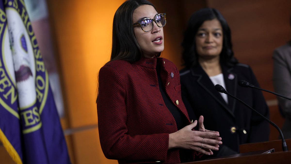 Alexandria Ocasio-Cortez (D-NY) (L), joined by Rep. Pramila Jayapal (D-WA), speaks at a news conference on banning stock trades for members of Congress, on Capitol Hill, April 07, 2022 in Washington, DC. Lawmakers have introduced the, Ban Conflicted Trading Act, which would prohibit members of Congress and senior staff from purchasing and selling individual stocks or serving on the board of a for-profit company