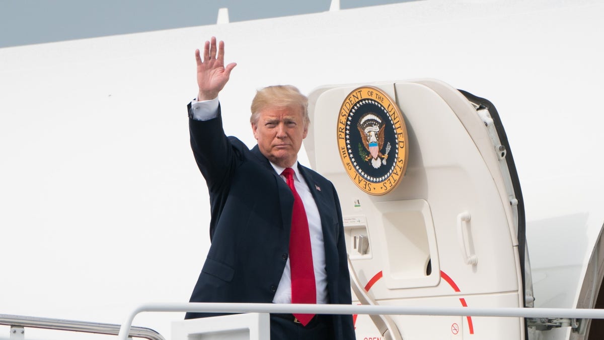 U.S. President Donald Trump waves while boarding Air Force One