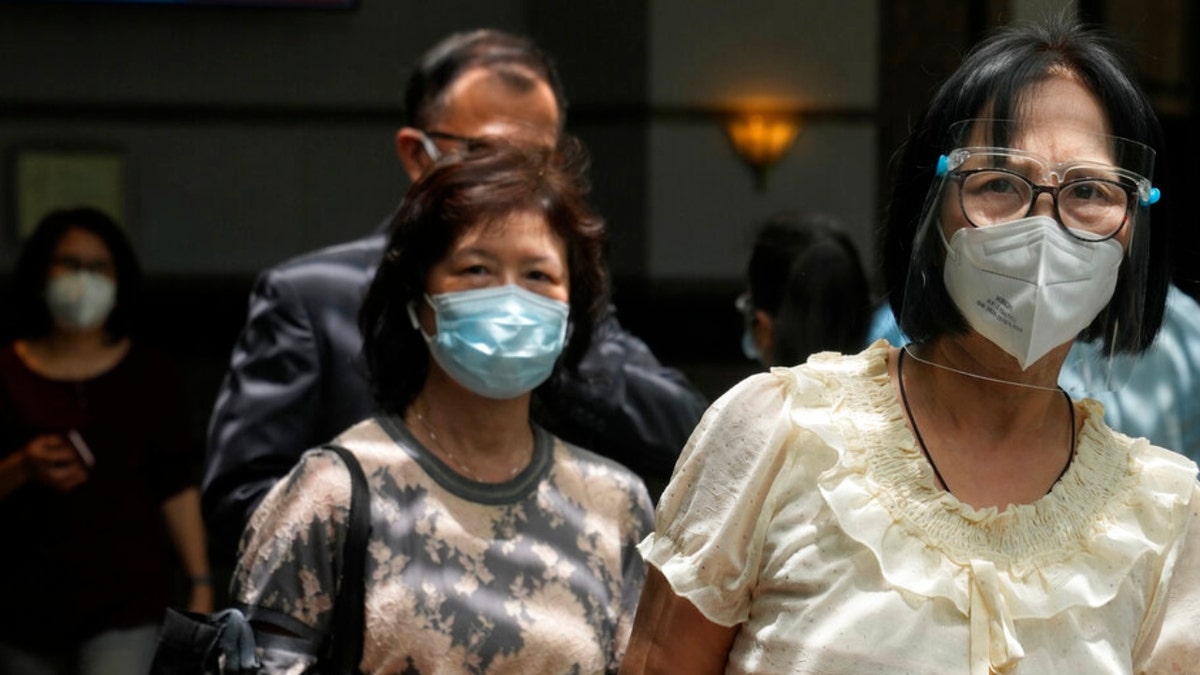 People wearing masks walk in Hong Kong