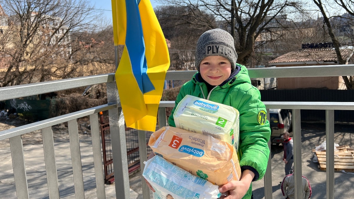 Ukrainian boy accepts donations from the International Ukrainian Crisis Fund.