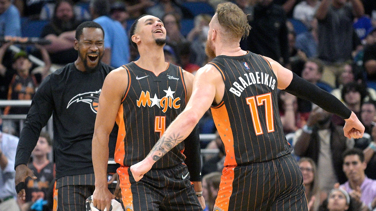 Orlando Magic forward Ignas Brazdeikis (17) celebrates with guard Jalen Suggs (4) and guard Terrence Ross, left, after Brazdeikis scored late in the second half of an NBA basketball game against the Cleveland Cavaliers, Tuesday, April 5, 2022, in Orlando, Fla. 