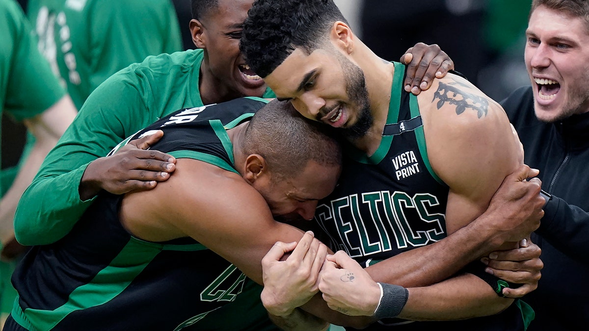 Boston Celtics center Al Horford, front left, and forward Jayson Tatum, front right, celebrate after Tatum made a layup at the buzzer to score and win Game 1 of an NBA basketball first-round Eastern Conference playoff series against the Brooklyn Nets, Sunday, April 17, 2022, in Boston. The Celtics won 115-114.