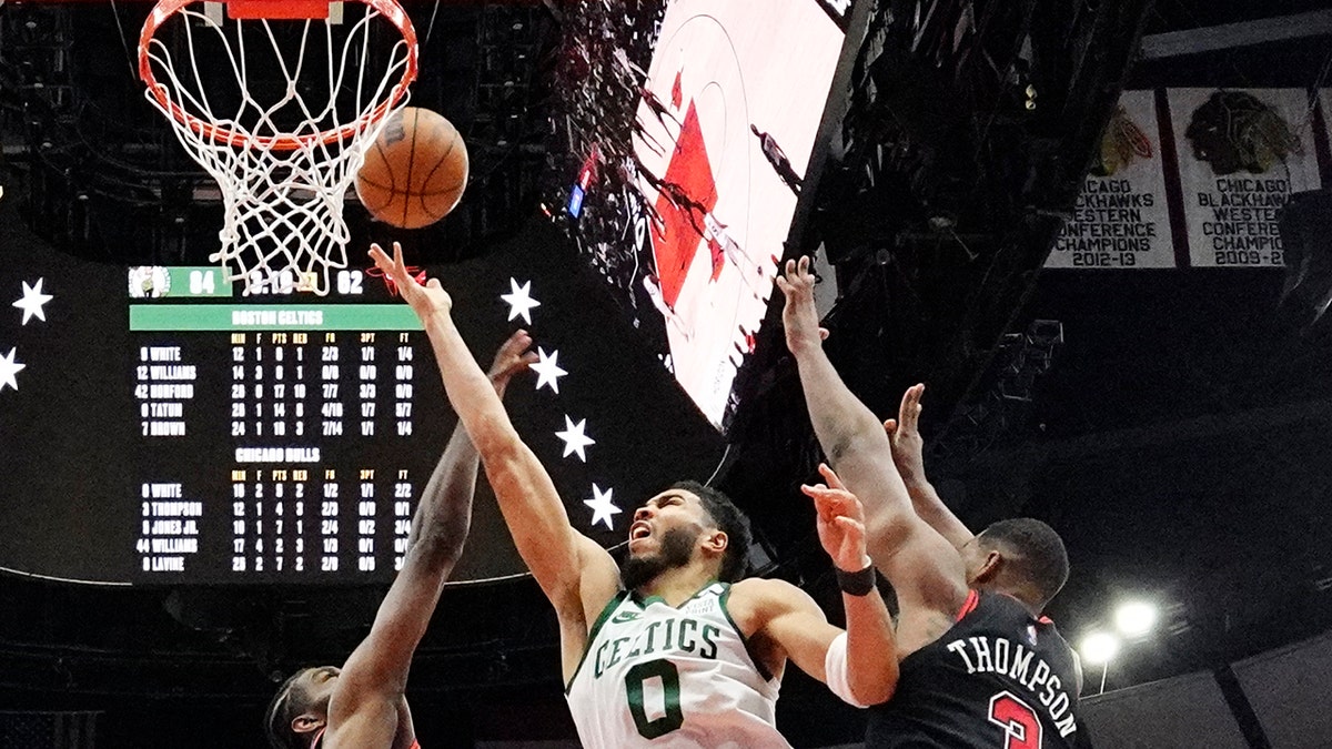 Boston Celtics forward Jayson Tatum (0) drives to the basket against Chicago Bulls forward Patrick Williams, left, and center Tristan Thompson during the second half of an NBA basketball game in Chicago, Wednesday, April 6, 2022. The Celtics won 117-94.