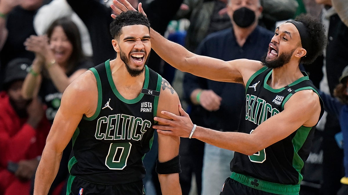 Boston Celtics forward Jayson Tatum (0) celebrates with guard Derrick White (9) after making a layup at the buzzer to score and win Game 1 of an NBA basketball first-round Eastern Conference playoff series against the Brooklyn Nets, Sunday, April 17, 2022, in Boston. The Celtics won 115-114.