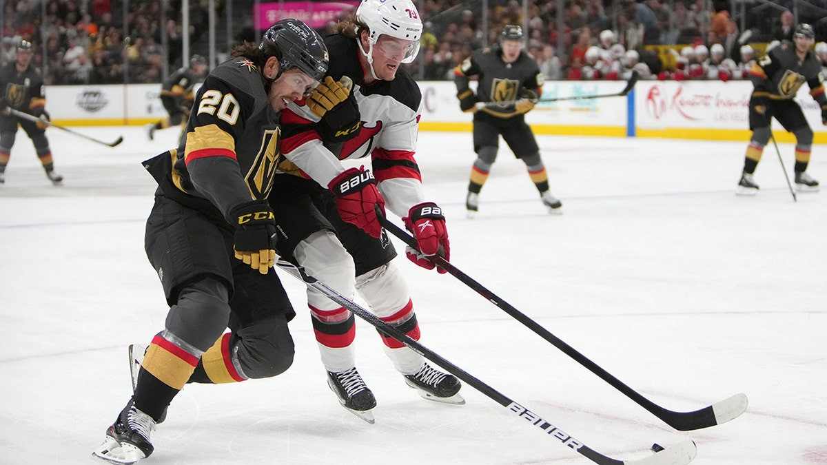 Vegas Golden Knights center Chandler Stephenson (20) and New Jersey Devils center Jesper Boqvist (70) vie for the puck during the second period of an NHL hockey game Monday, April 18, 2022, in Las Vegas.