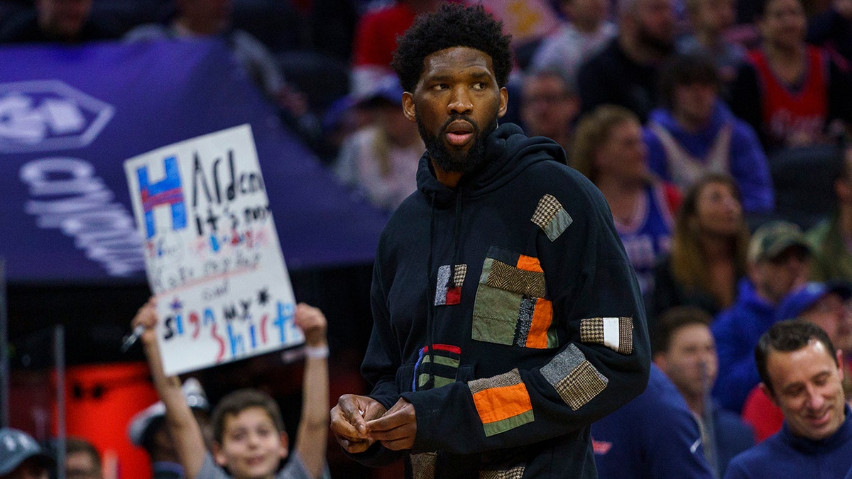Philadelphia 76ers' Joel Embiid looks on as he has the night off during the first half of an NBA basketball game against the Detroit Pistons, Sunday, April 10, 2022, in Philadelphia.