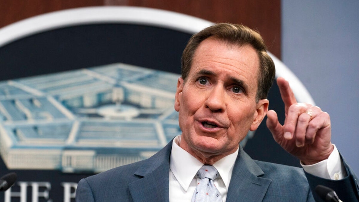 National Security Council Coordinator for Strategic Communications John Kirby speaks in a gray suit at press conference