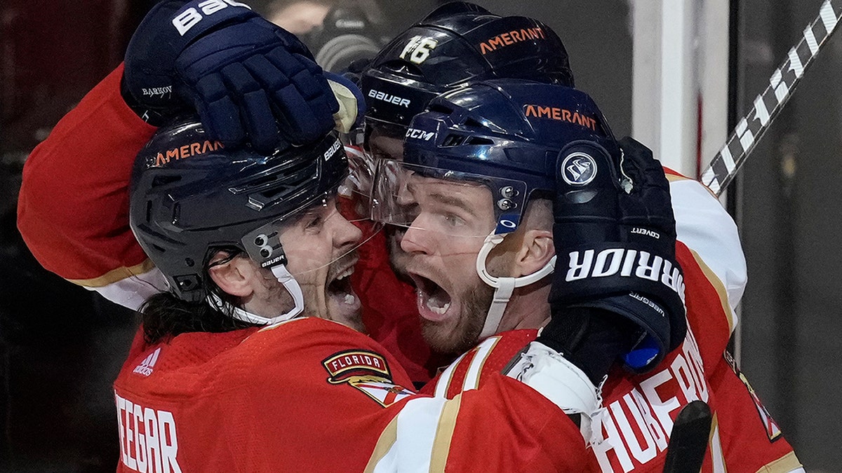 Florida Panthers left wing Jonathan Huberdeau, right, celebrates with teammates after scoring in overtime of the team's NHL hockey game against the Toronto Maple Leafs, Tuesday, April 5, 2022, in Sunrise, Fla.