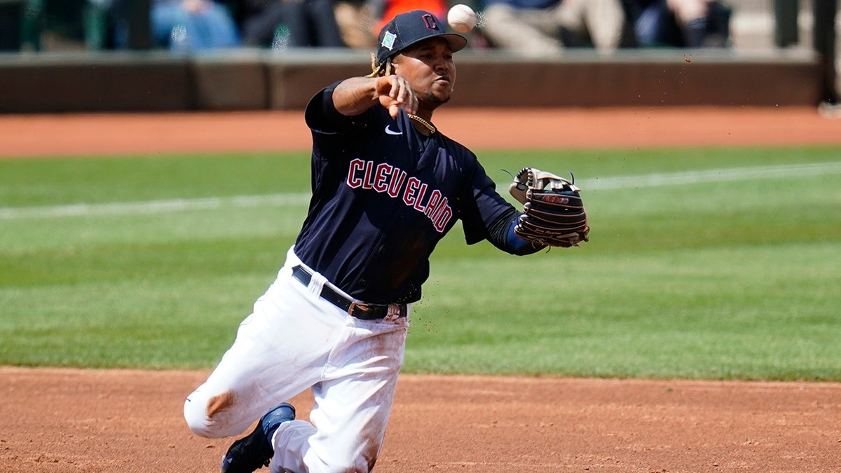 Cleveland Guardians third baseman Jose Ramirez throws from his knees to second base but is unable to get the force out on an infield single by Milwaukee Brewers' Pedro Severino during the third inning of a spring training baseball game Tuesday, March 29, 2022, in Goodyear, Ariz.