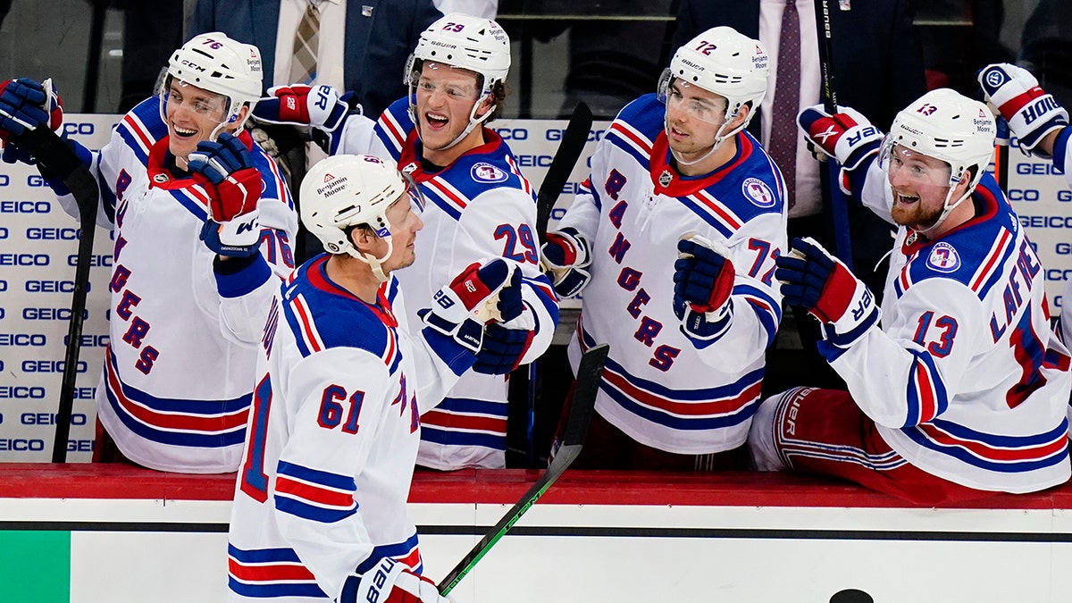 New York Rangers' Justin Braun (61) celebrates with teammates after scoring a goal during the third period of an NHL hockey game against the New Jersey Devils, Tuesday, April 5, 2022, in Newark, N.J. The Rangers won 3-1.