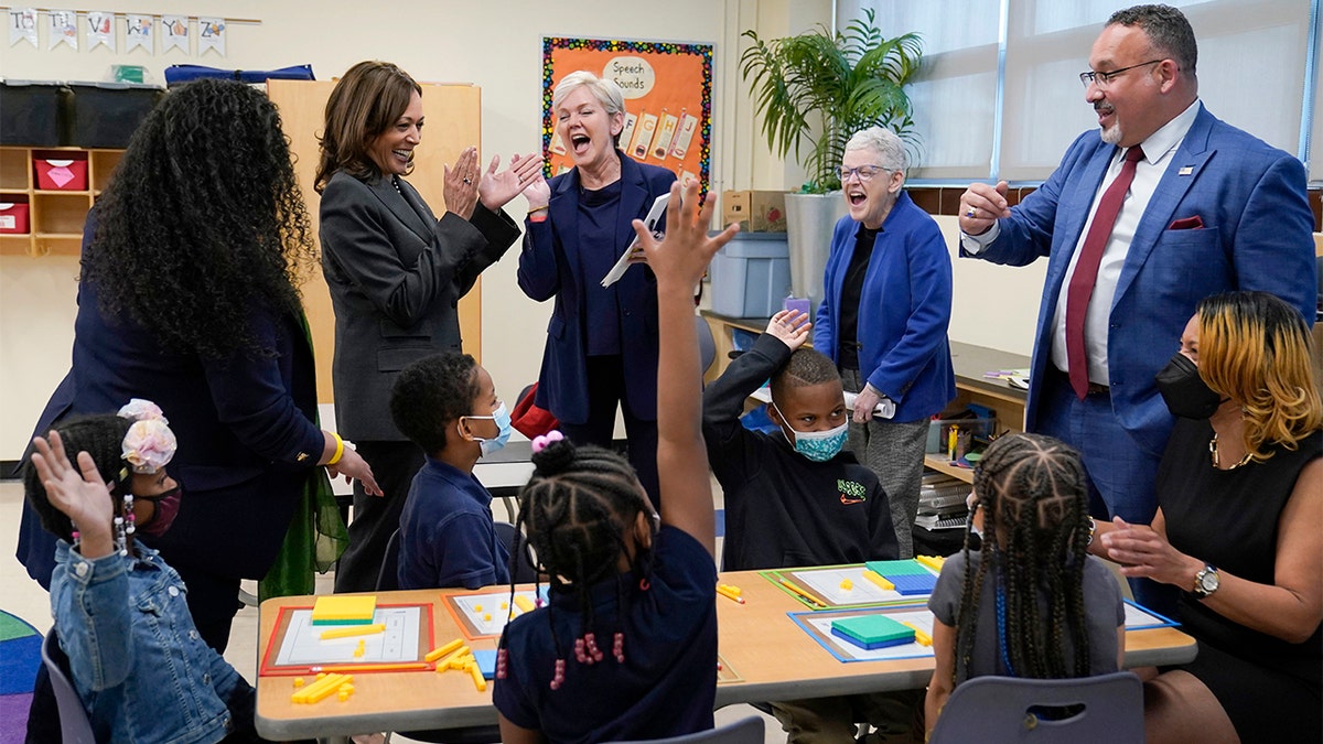 Vice President Kamala Harris, second from left, shares a laugh with, standing left to right, Thomas Elementary School principal Jaimee Trahan, Energy Secretary Jennifer Granholm, National Climate Adviser Gina McCarthy, and Education Secretary Miguel Cardona, during a visit with students and staff at Thomas Elementary School in Washington, Monday, April 4, 2022. (AP Photo/Susan Walsh)