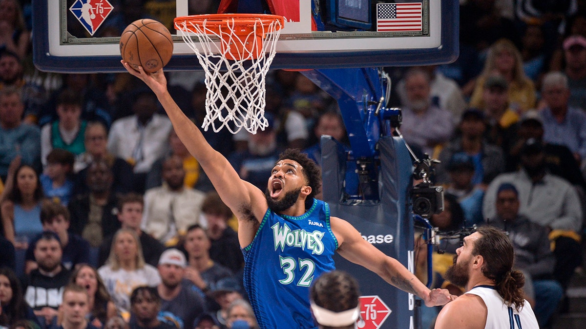 Minnesota Timberwolves center Karl-Anthony Towns (32) shoots ahead of Memphis Grizzlies center Steven Adams (4) during the first half of Game 1 of a first-round NBA basketball playoff series Saturday, April 16, 2022, in Memphis, Tenn.