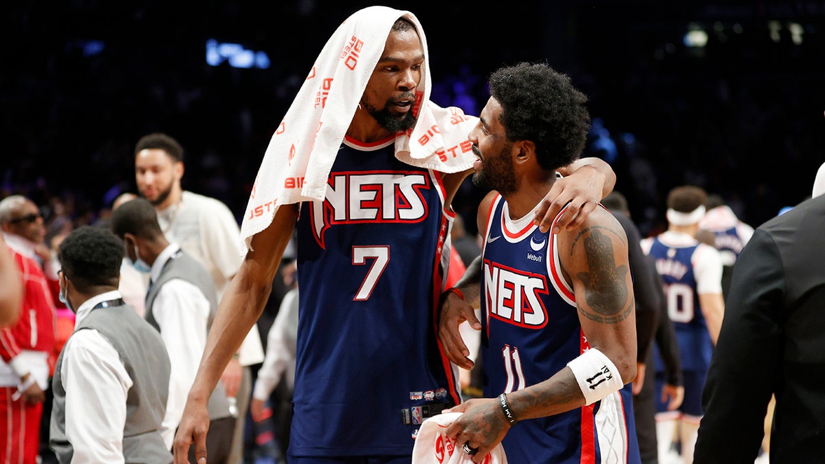 Kevin Durant, left, talks with Nets' teammate Kyrie Irving during the Cleveland Cavaliers game at Barclays Center on April 8, 2022, in Brooklyn. 