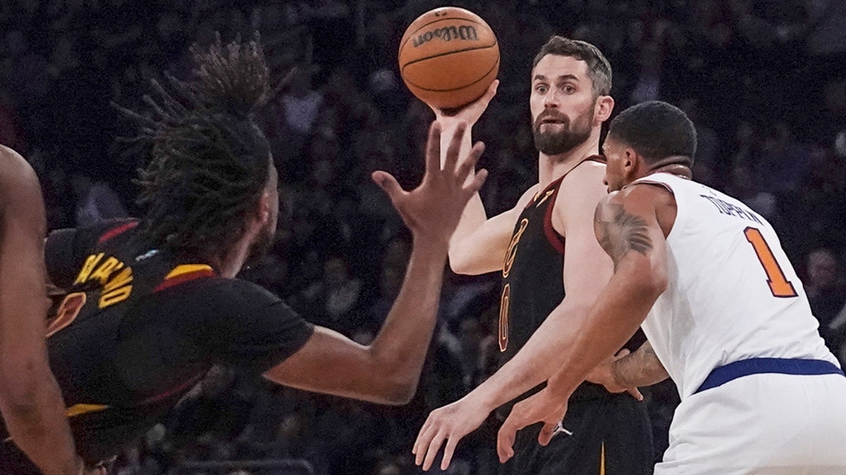 Cleveland Cavaliers forward Kevin Love, center, prepares to pass ball to Cleveland Cavaliers guard Darius Garland, left, during the second half of an NBA basketball game, Saturday April 2, 2022, in New York.?