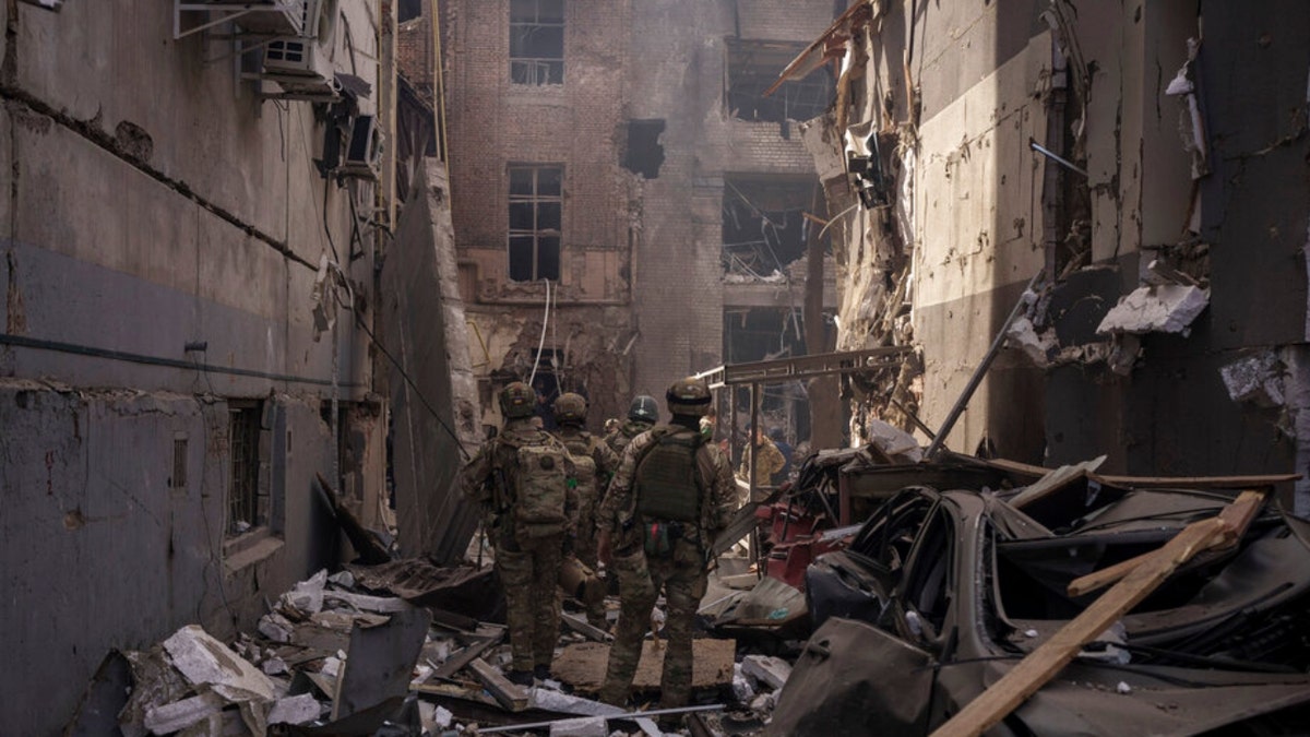 Ukrainian servicemen walk among debris in Kharkiv