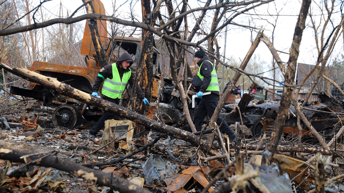 Ukrainian police forensic investigators examine an area with burnt Russian military vehicles destroyed during fighting, in the village of Bervytsia, near Brovary, northeast of Kyiv, on Thursday, April 21.