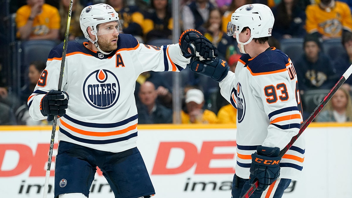 Edmonton Oilers' Leon Draisaitl (29) is congratulated by Ryan Nugent-Hopkins (93) after Draisaitl scored a goal against the Nashville Predators in the first period of an NHL hockey game Thursday, April 14, 2022, in Nashville, Tenn.