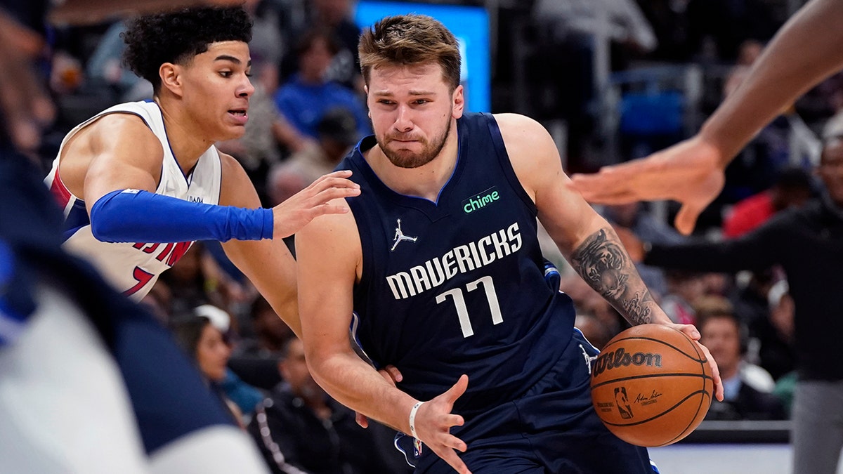 Dallas Mavericks guard Luka Doncic (77) is defended by Detroit Pistons guard Killian Hayes (7) during the second half of an NBA basketball game, Wednesday, April 6, 2022, in Detroit.