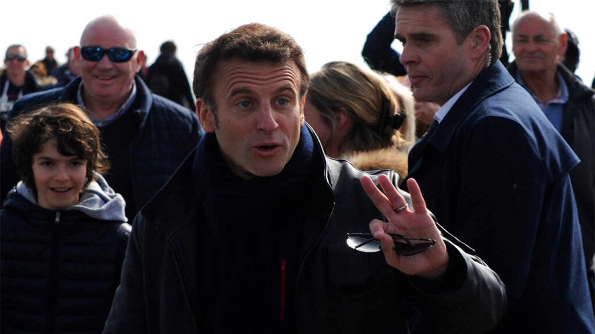 French President and centrist presidential candidate for reelection Emmanuel Macron gestures as he strolls after voting for the first round of the presidential election, Sunday, April 10, 2022 in Le Touquet, northern France.?