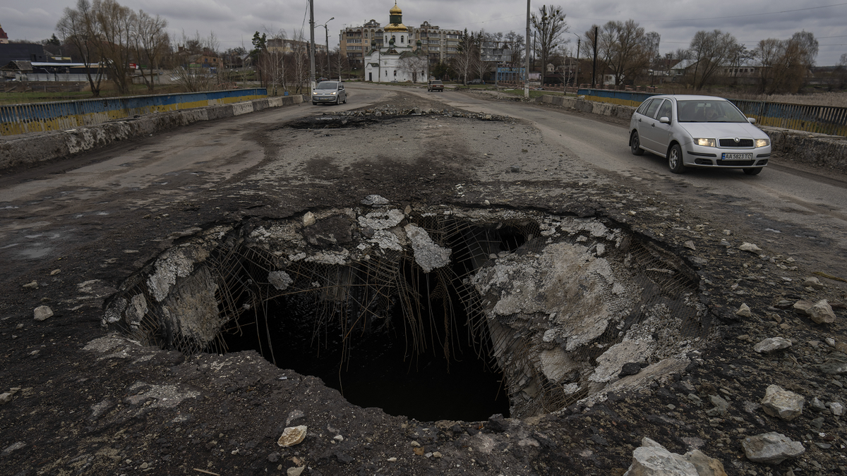 Cars drive near a damaged bridge following a Russian attack in the previous weeks in the town of Makarov in the Kyiv region on Sunday.