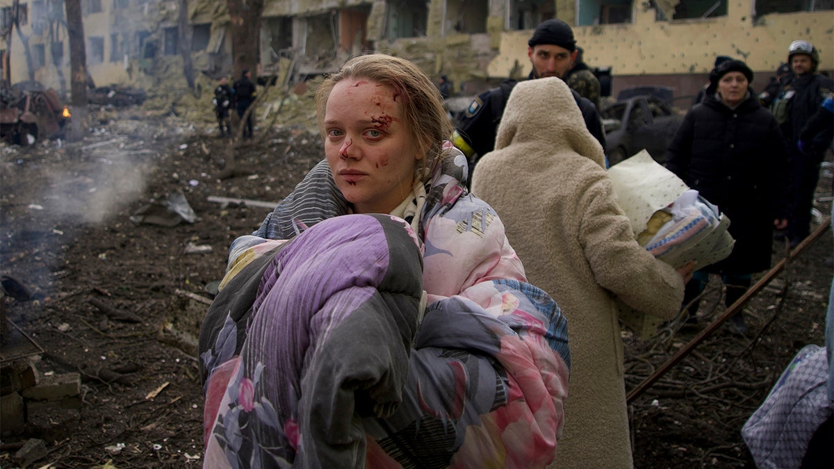 FILE - Marianna Vishegirskaya stands outside a maternity hospital that was damaged by shelling in Mariupol, Ukraine, Wednesday, March 9, 2022. (AP Photo/Mstyslav Chernov, File)