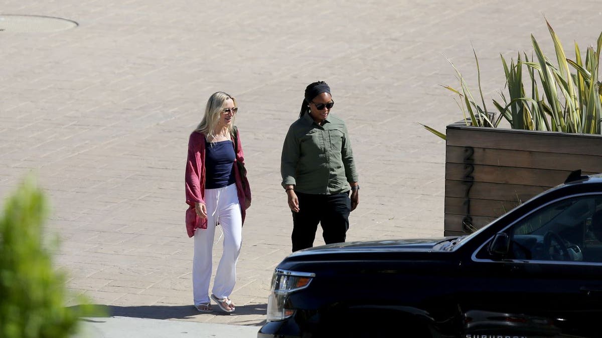 Melissa Cohen walks with Secret Service in Malibu