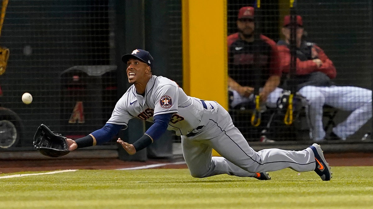 Houston Astros' Michael Brantley catches a fly out hit by Arizona Diamondbacks' Geraldo Perdomo during the third inning of a baseball game, Tuesday, April 12, 2022, in Phoenix.