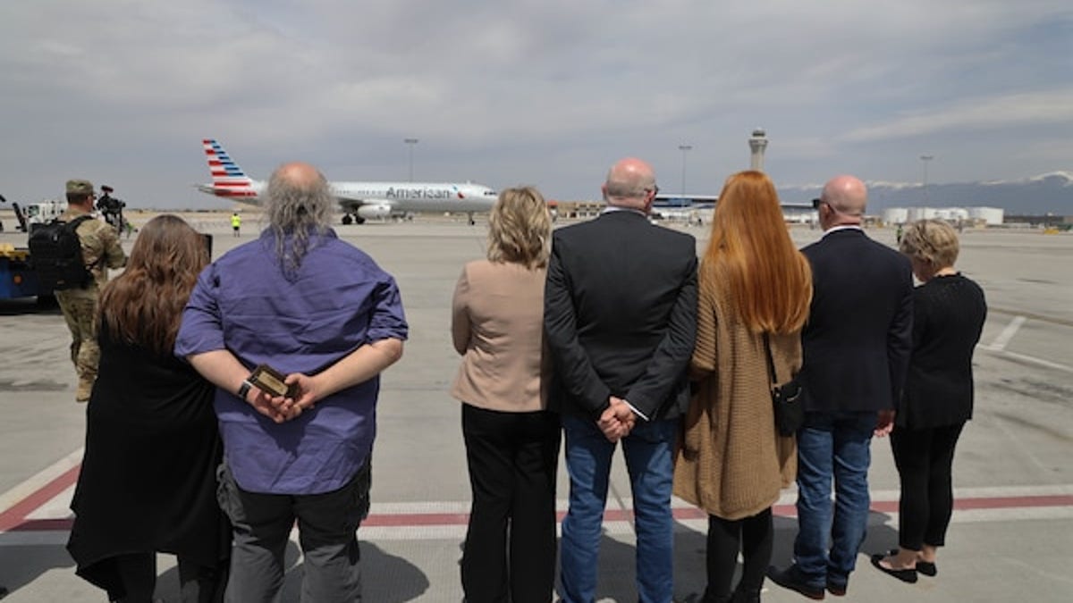 Surviving members of Army Cpl. David B. Milano's family await the arrival of his casket on the tarmac of Salt Lake City International Airport.