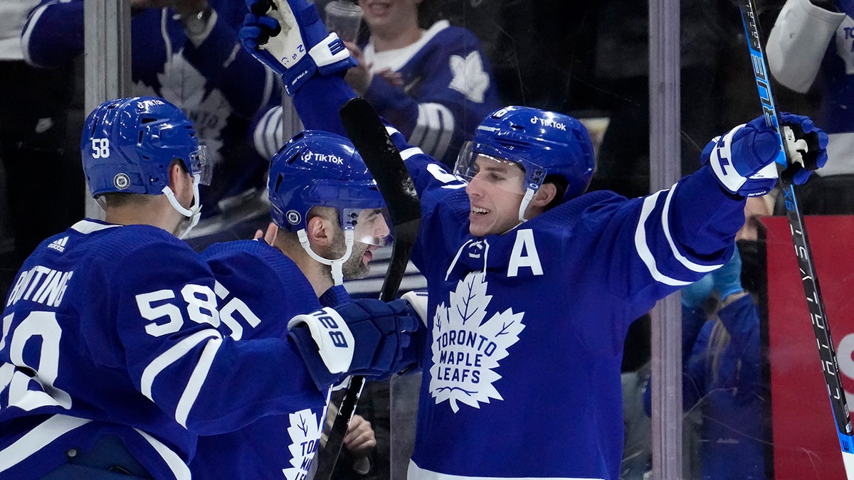 Toronto Maple Leafs right wing Mitchell Marner (16) celebrates his goal with teammates Michael Bunting (58) and Mark Giordano (55)  during first period NHL hockey game in Toronto, Sunday, April 17, 2022. 