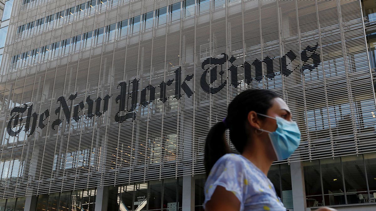 Woman walking in front of the New York Times building.