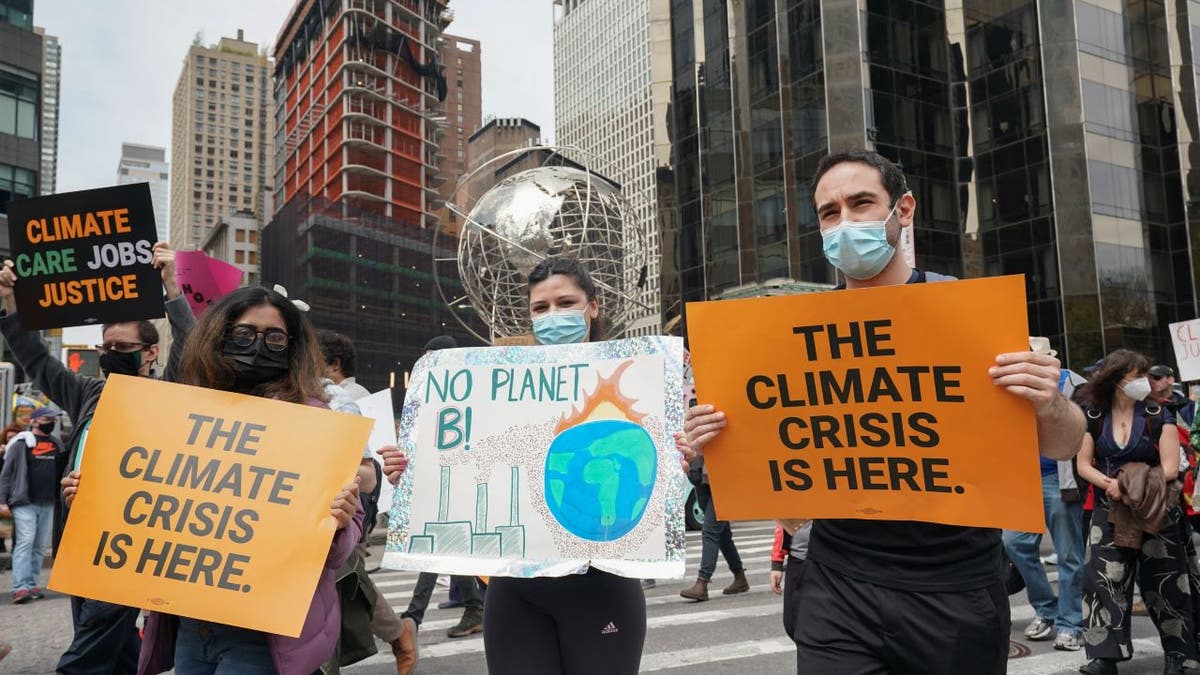 People carry signs at the March for Science in collaboration with Extinction Rebellion NYC and other organizations