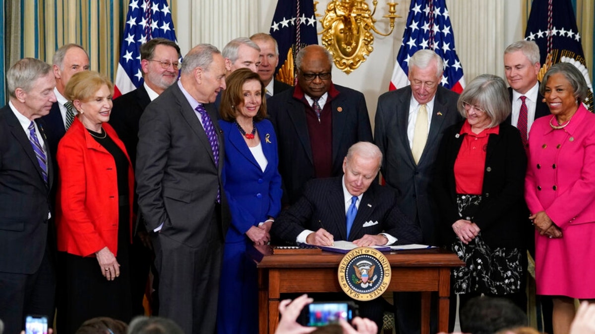 President Joe Biden signs the Postal Service Reform Act of 2022 in the State Dining Room at the White House in Washington, Wednesday, April 6, 2022. The long-fought postal overhaul has been years in the making. It comes amid widespread complaints about mail service slowdowns. (AP Photo/Susan Walsh)