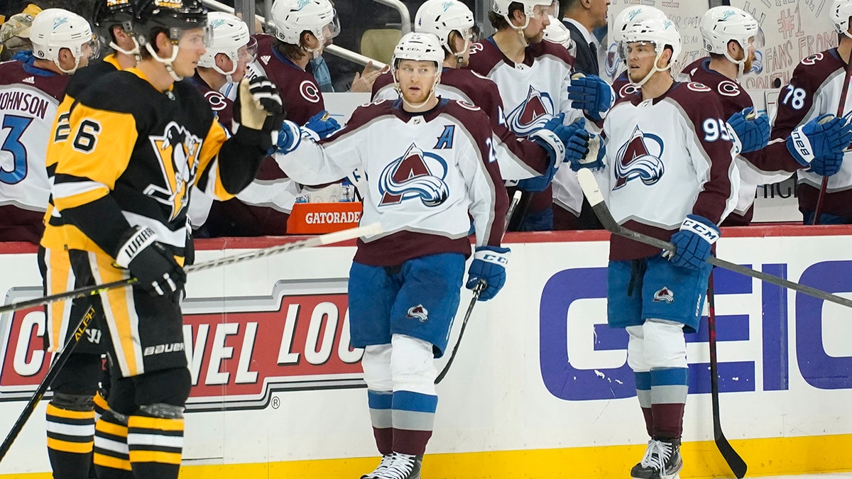 Colorado Avalanche's Nathan MacKinnon, center, celebrates with teammates on the bench after scoring against the Pittsburgh Penguins during the second period of an NHL hockey game, Tuesday, April 5, 2022, in Pittsburgh.