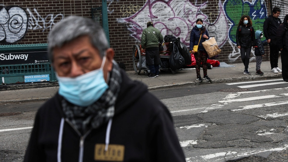 Masked man walks across street in New York City
