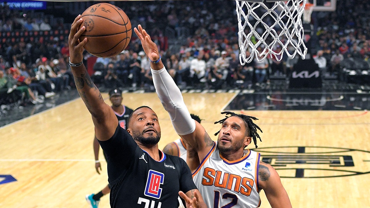 Los Angeles Clippers forward Norman Powell, left, shoots as Phoenix Suns forward Ish Wainright defends during the first half of an NBA basketball game Wednesday, April 6, 2022, in Los Angeles. 