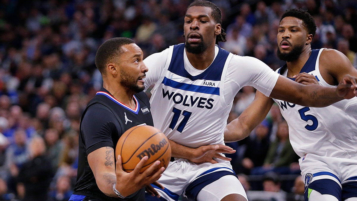 Los Angeles Clippers forward Norman Powell (24) drives on Minnesota Timberwolves' Naz Reid (11) and Malik Beasley (5) during the first quarter during an NBA basketball game Tuesday, April 12, 2022, in Minneapolis.