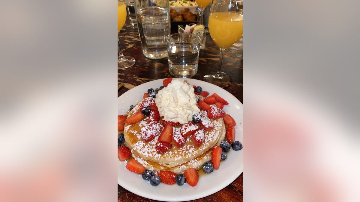 Strawberry and blueberry pancakes topped with whipped cream at NYC restaurant