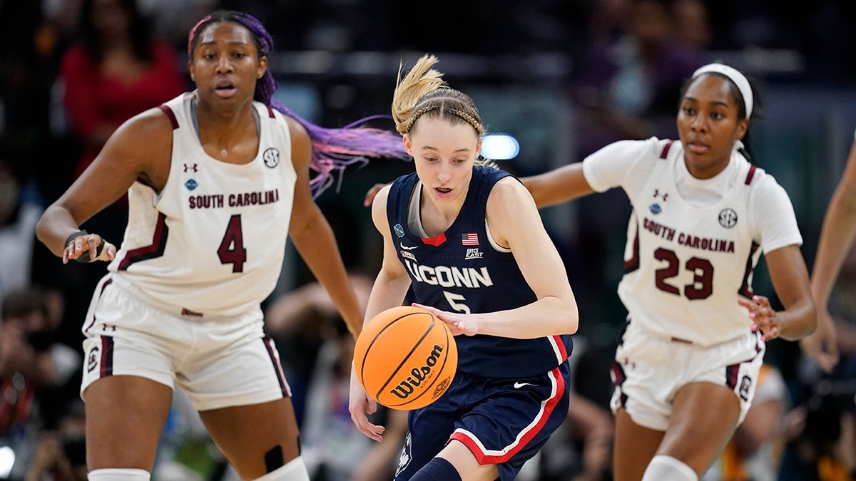 UConn's Paige Bueckers looks to get past South Carolina's Aliyah Boston and Bree Hall during the first half of a college basketball game in the final round of the Women's Final Four NCAA tournament Sunday, April 3, 2022, in Minneapolis.