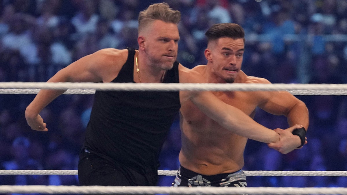 Pat McAfee (black pants) and Austin Theory (black trunks) wrestle during WrestleMania at AT&T Stadium in Arlington, Texas, on Apr 3, 2022.